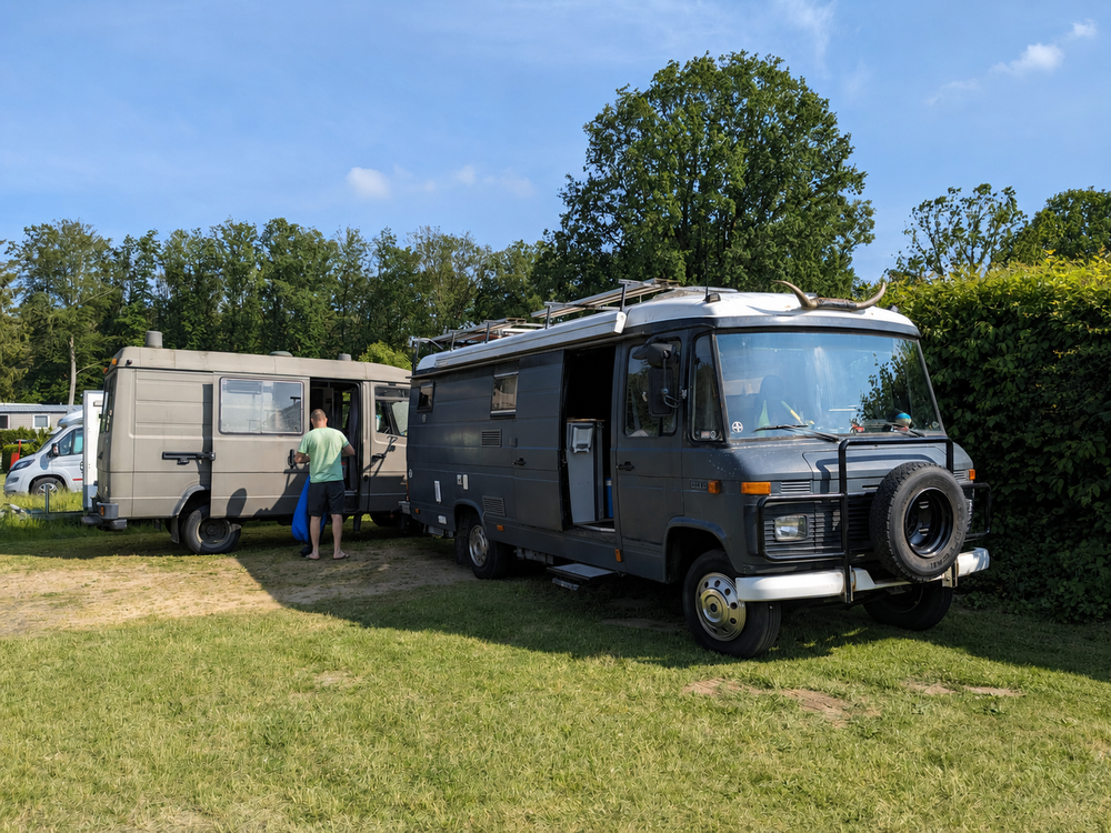 Originalfoto: zwei Campingbusse auf einer Wiese unter Bäumen – Vorlage für die Gravur
