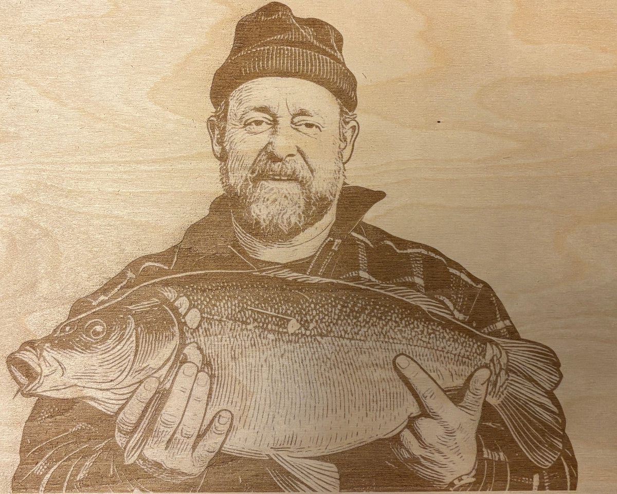 Fertiges Holzbild aus Buche: derselbe Angler mit dem Karpfen als Lasergravur, fotografiert